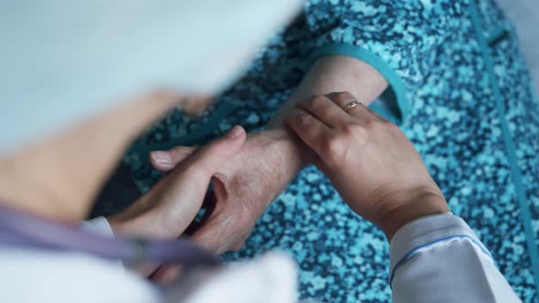 Closeup of Medic's Hands Checking Pulse in Elderly Woman Coronavirus Infection Test