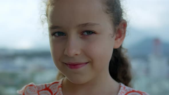 Portrait Little Child Girl Looking at Camera Standing on Street in City on Summer Day