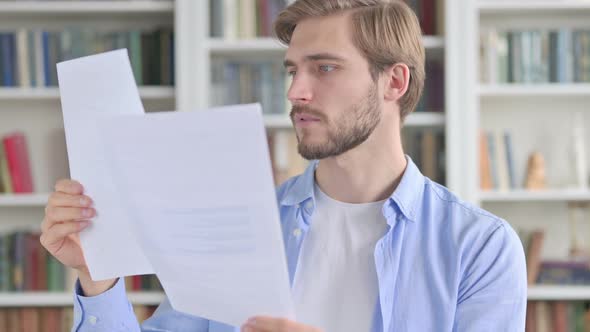 Portrait of Upset Man Reading Documents