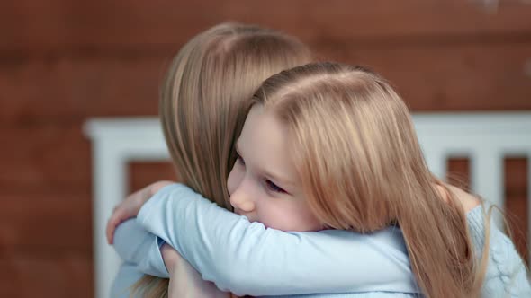 Side View Closeup Cute Baby Girl Enjoying Hugging with Mother at Home