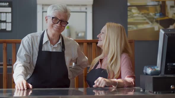 Portrait Of Senior Male And Female Coffee Shop Owners Standing At Sales Desk