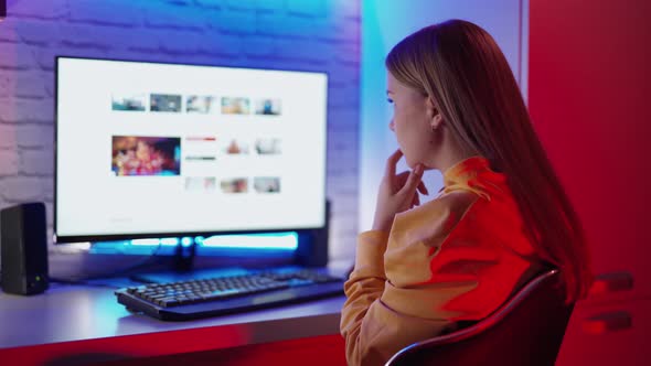 Girl using computer at home. Woman with computer while sitting at home