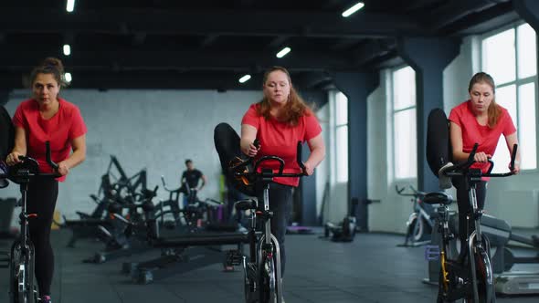 Group of Girls Performs Aerobic Training Workout Cardio Routine on Bike Simulators Cycle Training