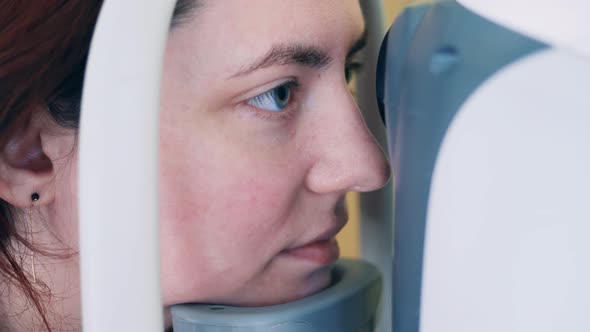 A Lady is Having Her Eyesight Checked By a Machine