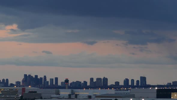 Time-lapse of a city skyline with skyscraper buildings at the horizon at sunset, wide shot