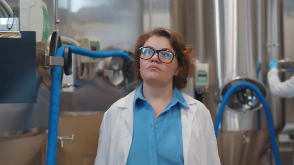 Portrait of Confident Female Scientist in Lab Coat Walking in Modern Beer Factory