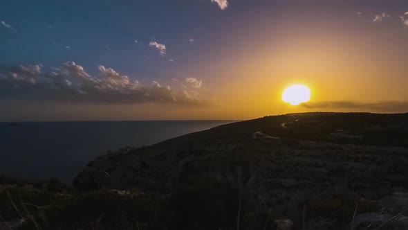Beautiful colors at sunset over ocean, Blue Grotto, Malta, timelapse