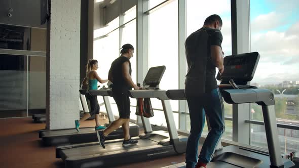 Back View of Running on Treadmill Sporty People Indoor of Modern Gym