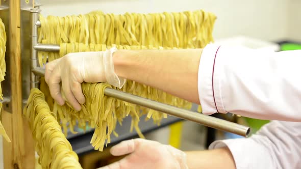 A Worker Takes Down Dried Pasta From Stand - Closeup