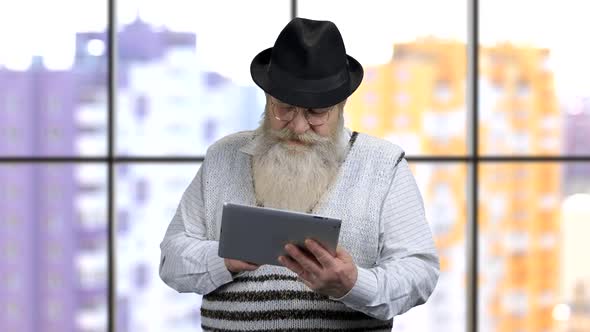 Old Grandpa with Tablet Scrolling His Social Media Feed on Tablet Pc