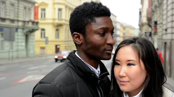 Happy Couple Look To the Side (Shop Window) - Black Man and Asian Woman - Urban Street with Cars