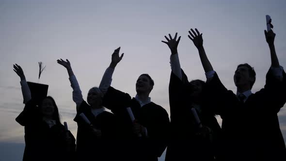 Graduation Caps Are Tossed Into the Air By a Happy Group of Friends.