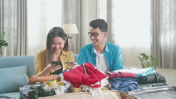 Asian Couple Booking On Smartphone With Credit Card For A New Journey. Luggage For Travel Holidays
