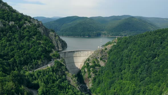 Aerial View of a Hydroelectric Dam in the Mountains Covered with Forest