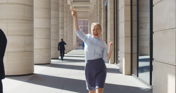 Happy Successful Young Businesswoman Dancing Outside Business Center Celebrating Promotion