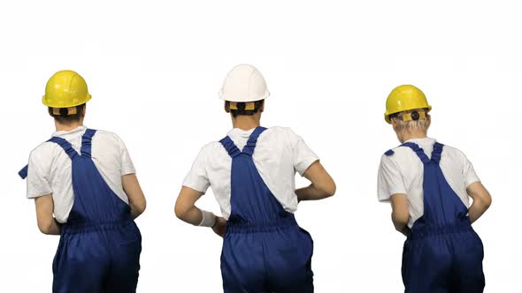 Three Male Construction Workers in Hard Hats Synch Dancing with Their Backs To the Camera on White