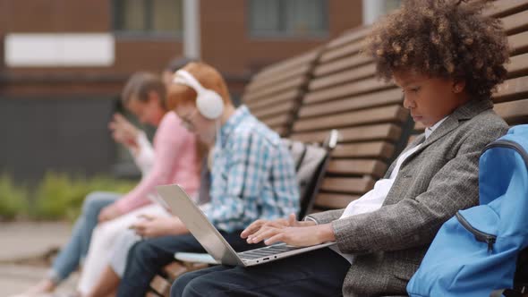 African Pupil Working on Laptop Outside