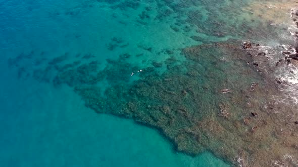 Aerial footage of snorkelers and stand up paddle boarders at the north reef of Keawakapu Beach.  Mau