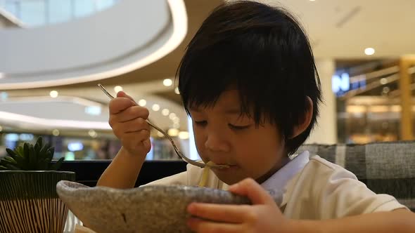 Cute Asian Child Eating Japanese Noodles In A Restaurant Slow Motion