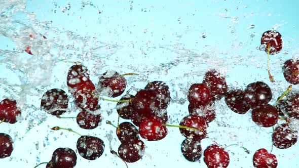 Super Slow Motion Shot of Flying Fresh Cherries and Water Side Splash at 1000Fps.