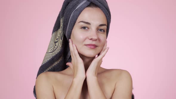 Woman with Towel on Her Head Looking at Camera Isolated on Pink Background