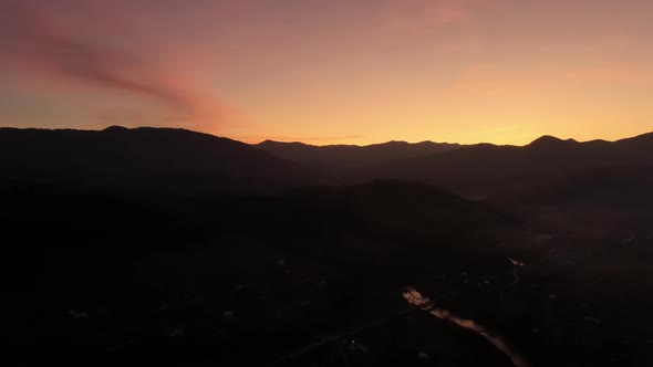 Majestic Drone View of Silhouette of Mountain Ridge Located Against Orange Sunset Sky in Evening in