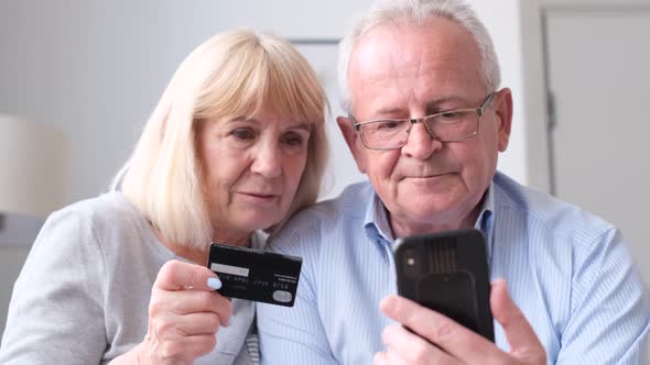 A Retired Couple is Shopping Online Using a Smartphone