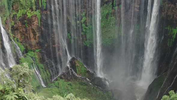 Aerial view of Tumpak Sewu waterfall in tropical forest, aerial footage