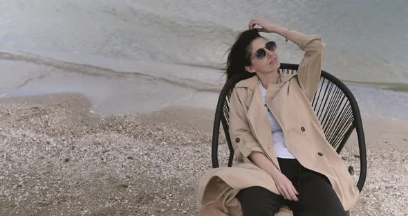 Portrait of Serene attractive young woman resting alone on chair taking deep breath of fresh air