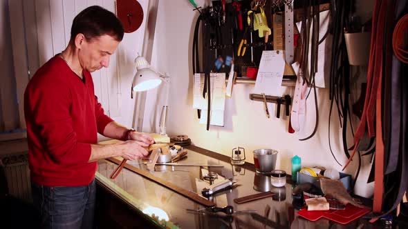 Tailor Cuts the Piece of Leather Using a Special Tool in His Personal Workshop