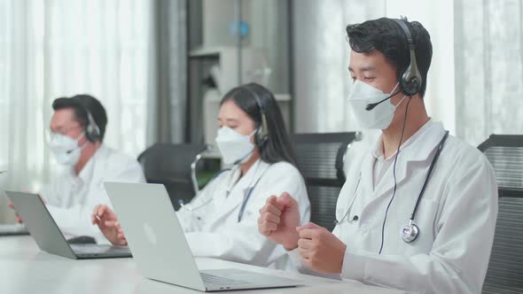 Success Of Three Asian Doctors With Stethoscopes In Headset And Masks Working As Call Centre Agents