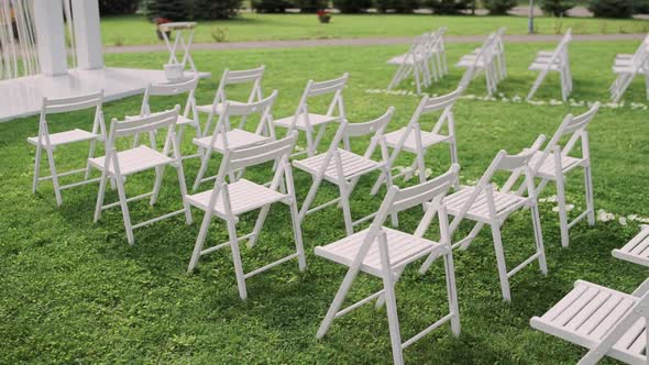 beautiful wedding arch in the park with white chairs