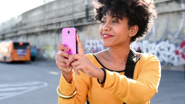 Half length of young beautiful afro curly hair woman holding a smart phone taking picture