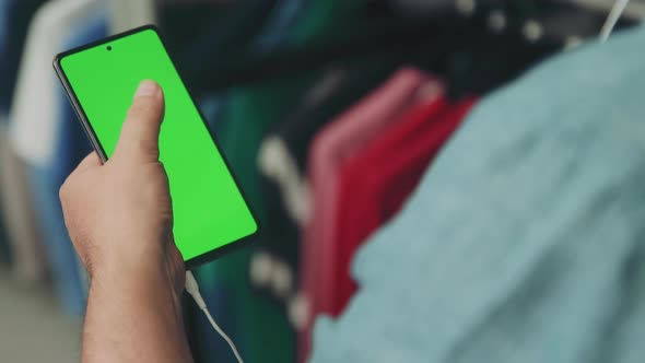 Man in Shirt Using Mobile Phone with Green Screen Scrolling through the Display while Watching and L