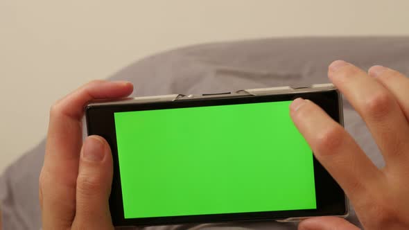 Blonde woman relaxing and scrolling through green screen smart phone screens 4K 2160p UltraHD footag