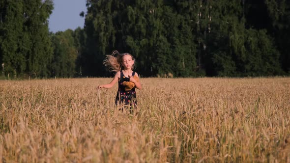 Cute Little Girl Running Through a Wheat Field