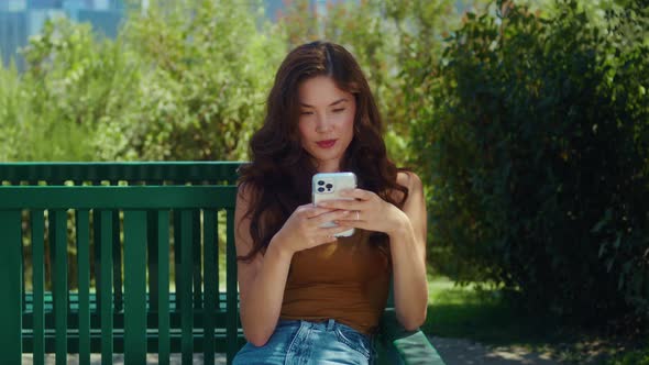 Focused Girl Surfing Internet on Park Bench Closeup