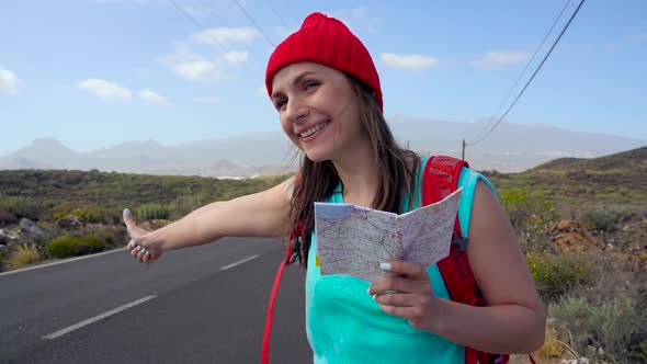 Traveler Woman Hitchhiking on a Sunny Road and Walking