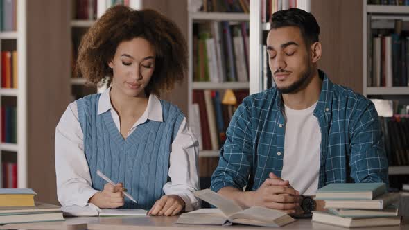 Two Students Sit at Desk in Classroom at Lesson Carefully Listen to Lecture Seminar Write Down