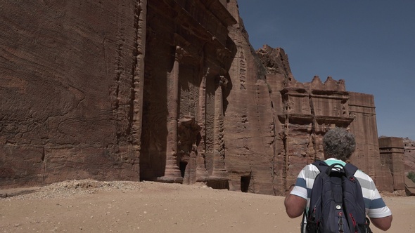 A traveler walks through the canyon of the ancient city of Petra.