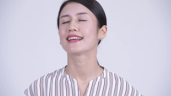 Face of Happy Beautiful Asian Businesswoman Relaxing with Eyes Closed