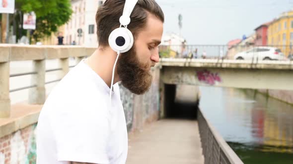 Young bearded man listening music