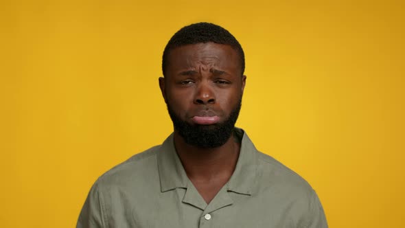 Upset Funny Young Black Man Pouting Lip And Looking At Camera