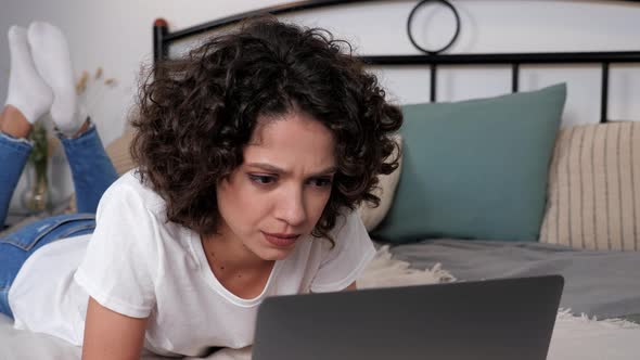 Focused Hispanic Curly Woman Student Study Uses Laptop Distance Education