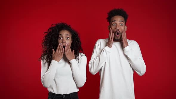 Amazed African American Man and Woman Shocked, Saying WOW. Young Couple 