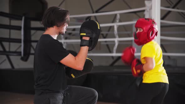 Little Smiling Boy in Protective Helmet Doing Boxing with a Young Coach