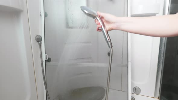 Mosquito Net is Washed in a Shower Cabin From a Watering Can