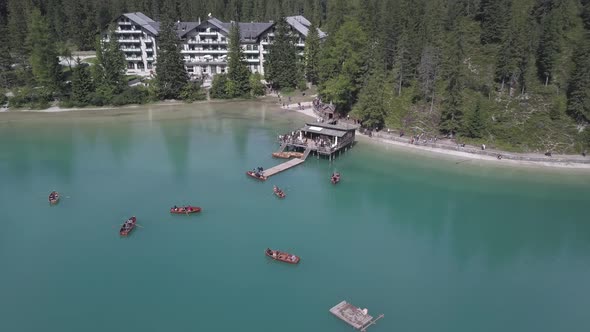 Paddle boaters in Lake Braies aka Pragser Wildsee in South Tyrol Italy with the Braies Hotel in the