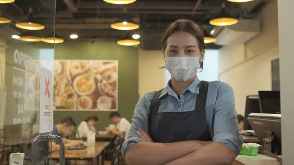 Portrait of Young woman restaurant owner wearing protective mask stand in in front of restaurant