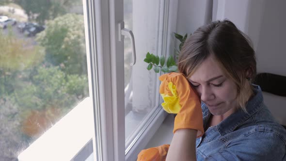 Sick Girl in Gloves Washes Window with Cleaning Spray and Sneezes Due To Respiratory Illness